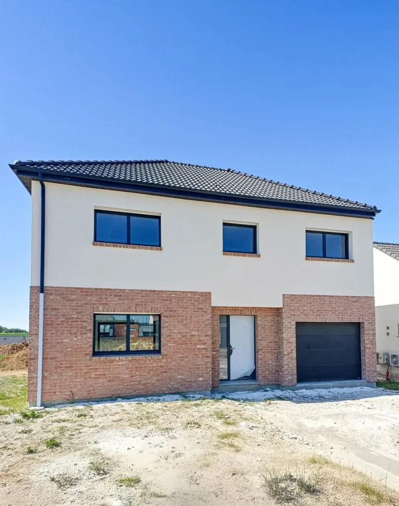Maison neuve en brique rouge et enduit blanc avec fenêtres gris anthracite, porte d'entrée et porte de garage posées par MD Menuiserie