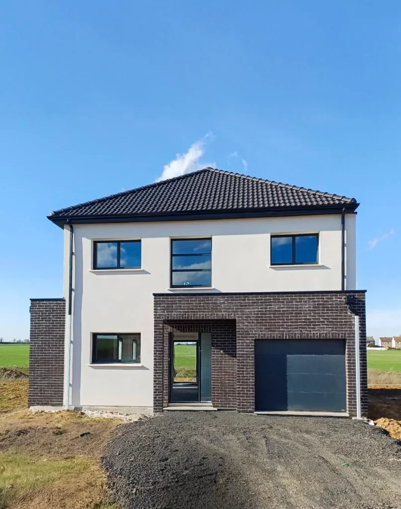 Maison neuve à étage en brique et enduit avec fenêtres et porte de garage gris anthracite posées par MD Menuiserie