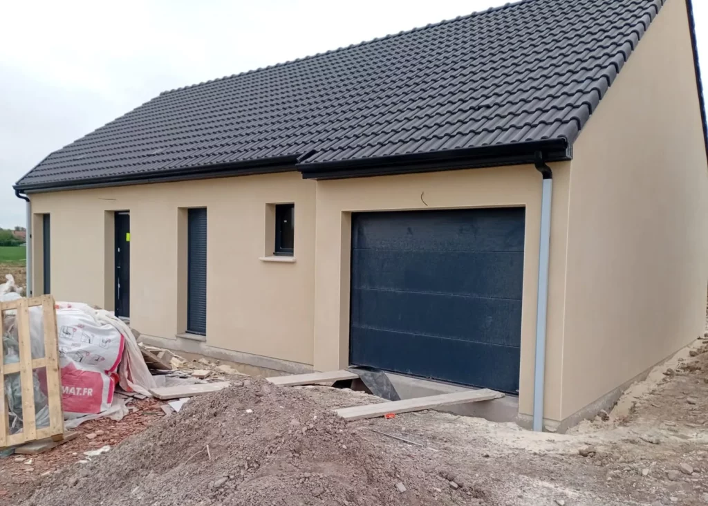 Porte de garage sectionnelle gris anthracite et fenêtres avec volets roulants sur une maison neuve, pose MD Menuiserie