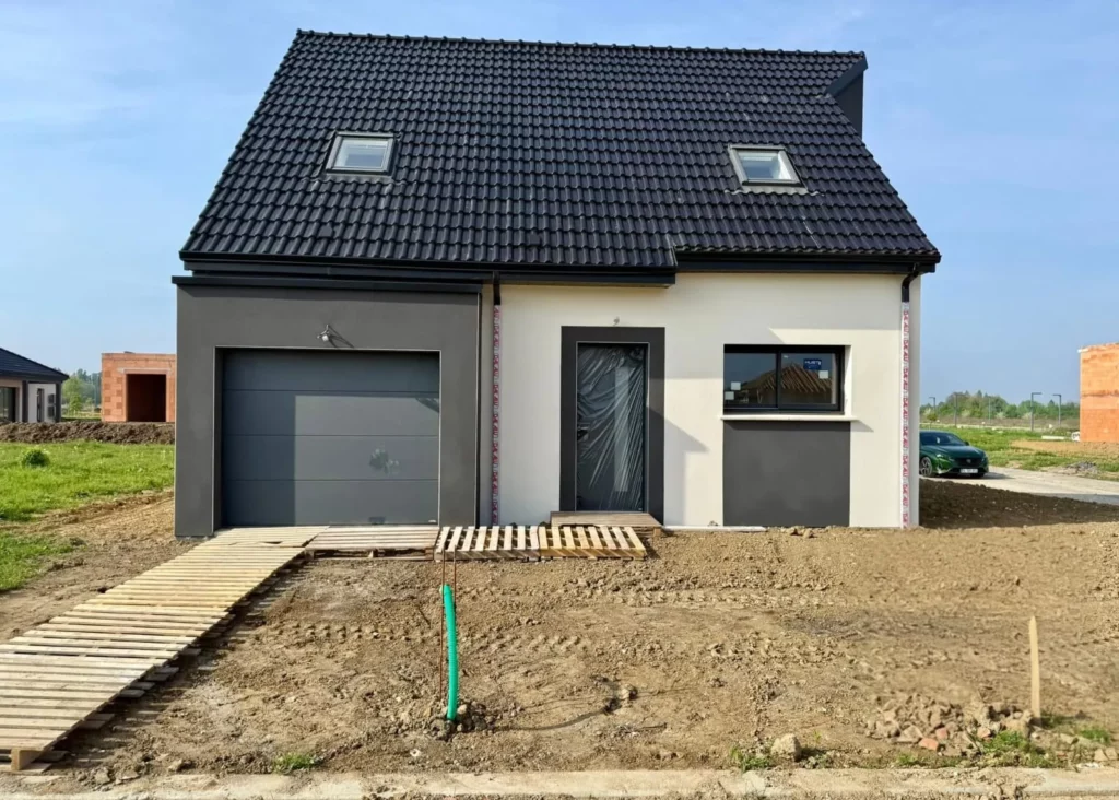 Maison neuve avec porte d'entrée vitrée, porte de garage sectionnelle et fenêtre gris anthracite posées par MD Menuiserie